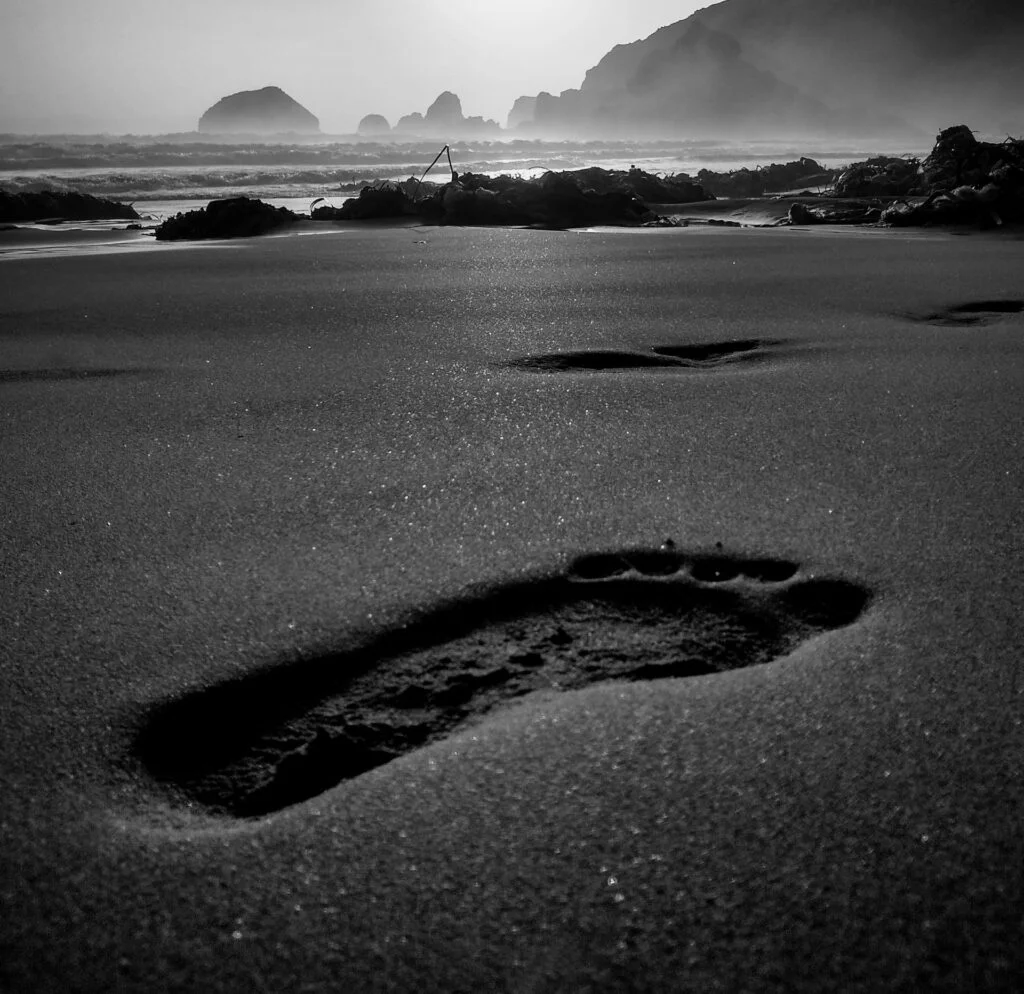 Grayscale Photo of Footprint in the Sand